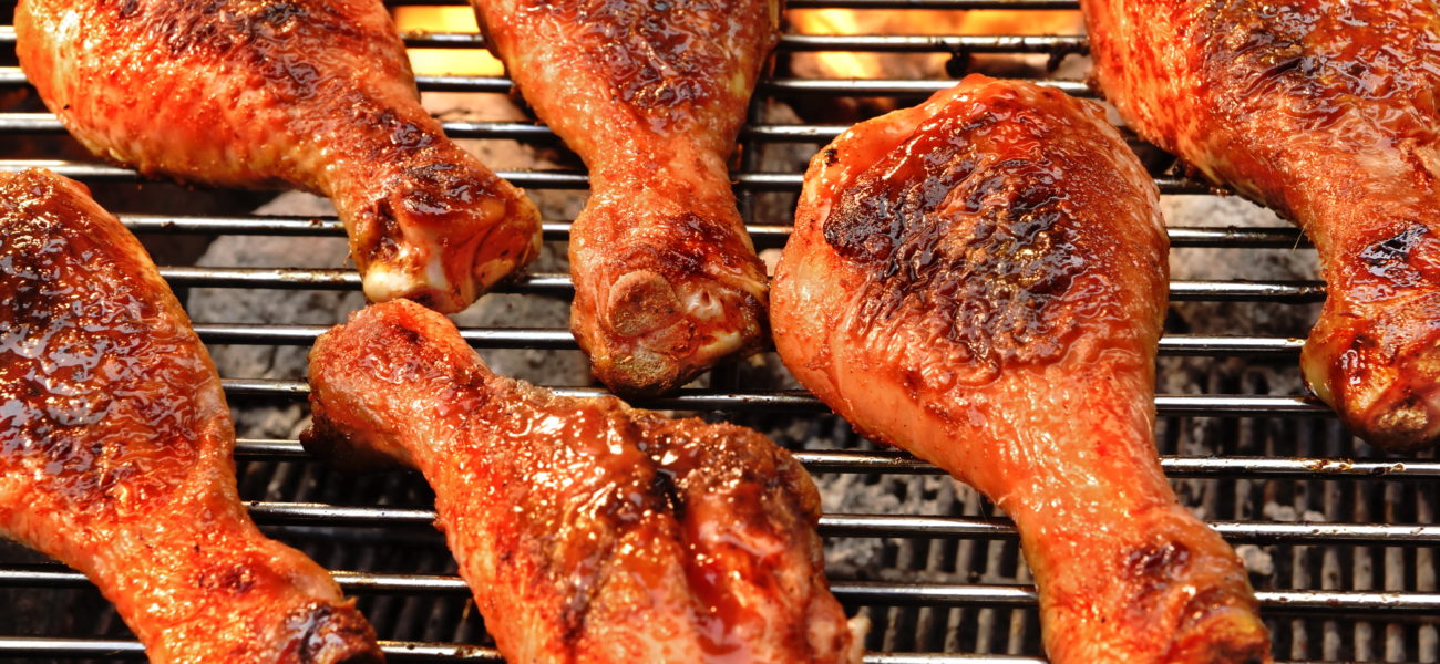 BBQ Chicken Legs Roasted On The Hot Flaming Charcoal Grill,